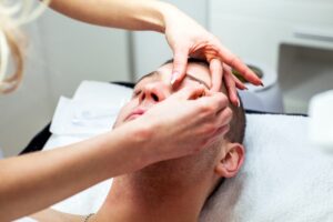 woman tweezing a man's eyebrows