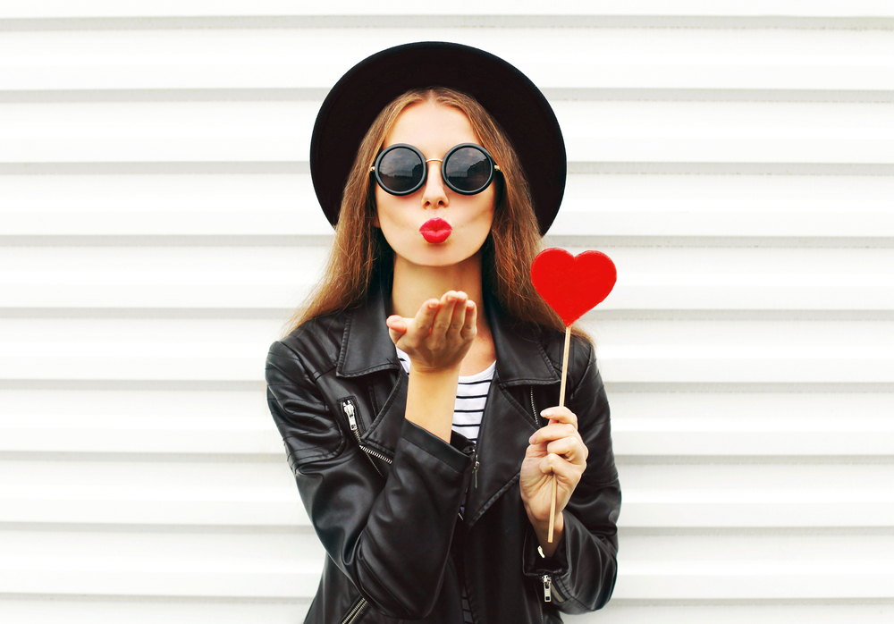 Girl in sunglasses blowing a kiss