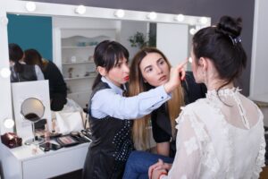 teacher teaching makeup to a student in beauty school