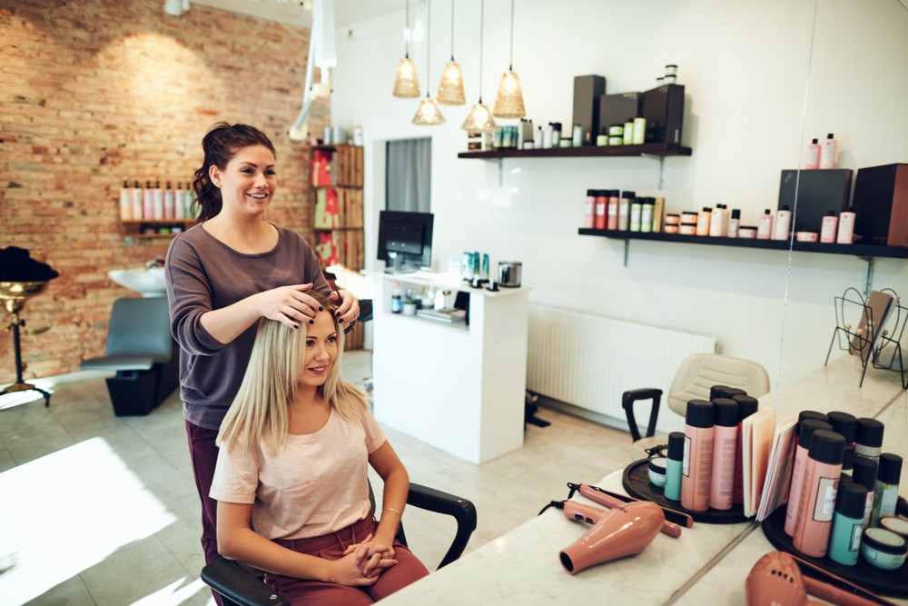 cosmetologist running her hands through clients curled hair