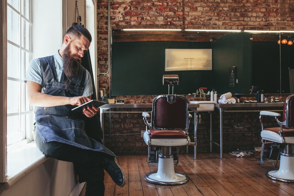 barber shop owner looking at iPad